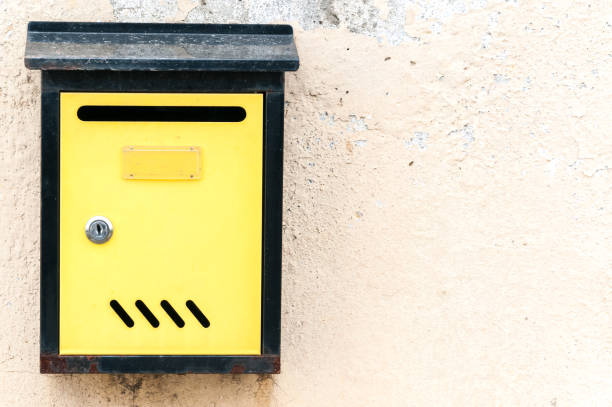 istock Yellow letterbox or mailbox on grunge old wall close up 900972050