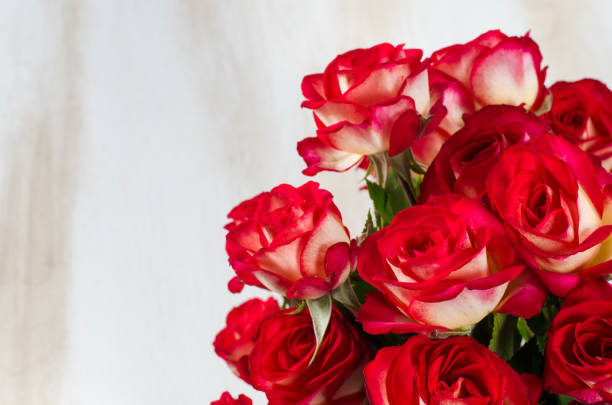 istock Red roses bouquet over white wooden table. 900973068