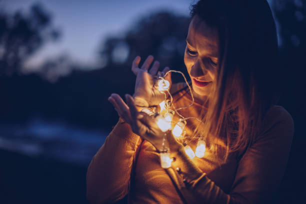 istock Smiling woman standing outdoors with lights 900979928