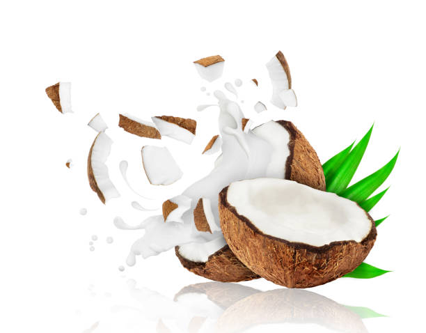 istock Broken coconut into two pieces with milk splashes, isolated on white background 900982798