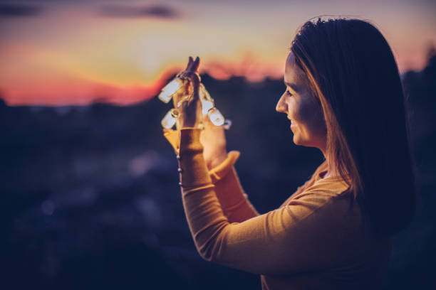 istock Young woman outdoors with lights 900982966