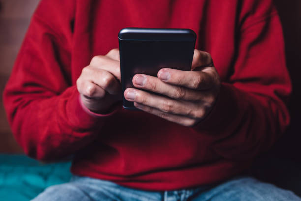 istock Young adult holding a smartphone 900994902