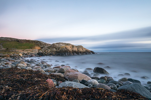Pebble shore at Hove, Tromoy in Arendal, Norway. Picture shows a part of Raet National Park. This national park was established in 2016, and includes marine and coastal areas in the municipalities of Arendal, Grimstad and Tvedestrand in Norway. Long exposure.