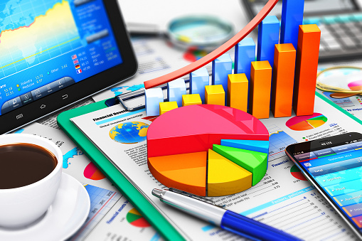 Creative abstract mobile office, stock exchange market trading, statistics accounting, financial development and banking business concept: 3D render illustration of the macro view of modern tablet computer PC and black glossy touchscreen smartphone or mobile phone with stock market application software, growth bar chart and pie diagram, ballpoint pen, electronic calculator, golden eyeglasses, report documents and cup of fresh hot coffee drink with selective focus effect