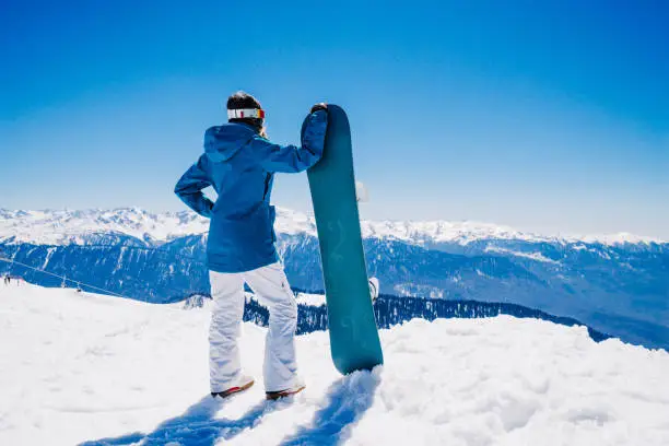 young  snowboarder woman at ski resort