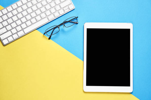 istock Top view, Modern workplace with tablet placed on a pastel yellow background. Copy space suitable for use in graphics. 901011876