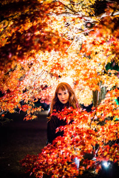 An Asian female model in autumn night background, wearing black leather and fur.