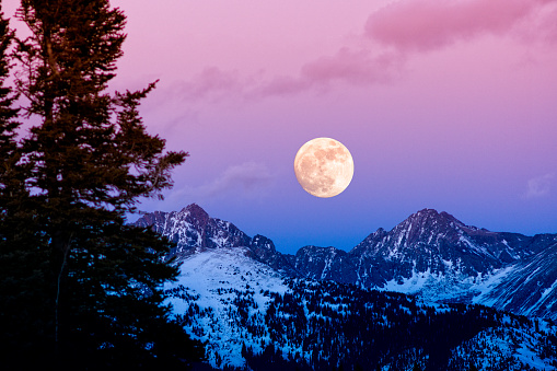 On August 3, 2023, as the supermoon was setting in the west the illusion of the moon resting on the side of Mount Rainier appeared.  Mount Rainier rises 14,411 feet above sea level in Washington State.