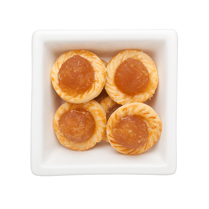 Pineapple tarts in a square bowl isolated on white background