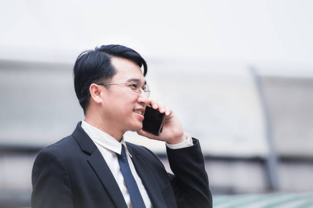 istock businessman using a cell phone and modern office building background 901053986