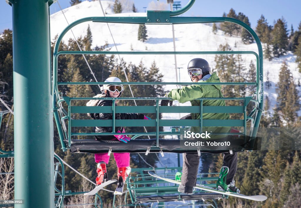 Father and daughter riding a chair lift together at a ski resort Smiling father and daughter riding a chair lift together on a sunny day at a ski resort Park City - Utah Stock Photo