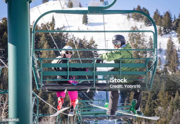 Father And Daughter Riding A Chair Lift Together At A Ski Resort Stock Photo - Download Image Now