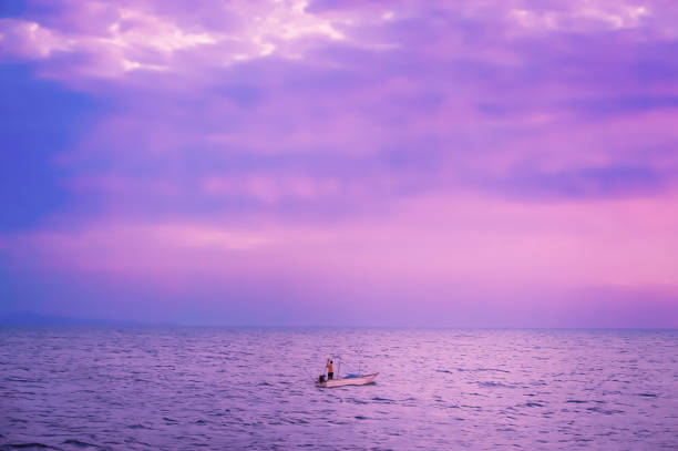 istock fisherman with boat and sea   with violet color filter effect 901063984