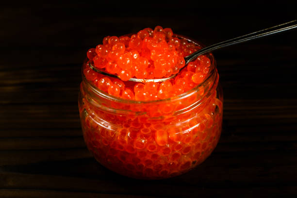 istock Red caviar in a spoon above the glass jar 901066948