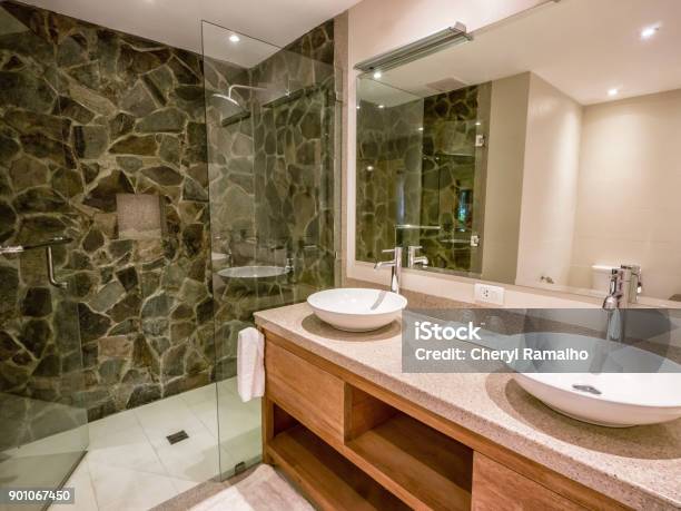 Modern Bathroom With Two Round White Vessel Sinks On Granite Counter Natural Stone And Glass Shower Enclosure Stock Photo - Download Image Now
