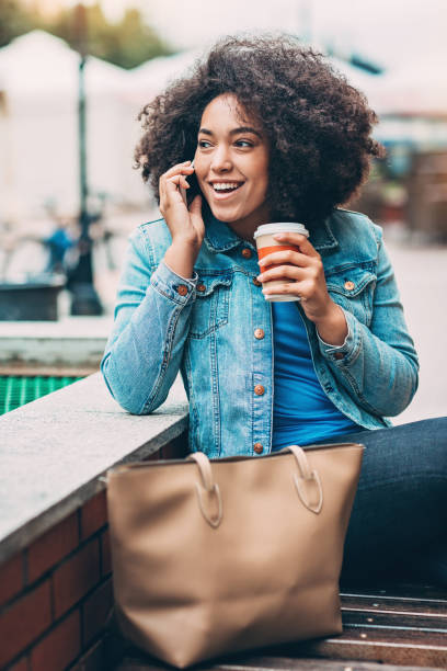 電話で話しているアフリカ民族の女の子の笑顔 - single line urban scene outdoors vertical ストックフォトと画像