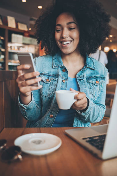 istock Young African ethnicity woman texting in a restaurant 901074642