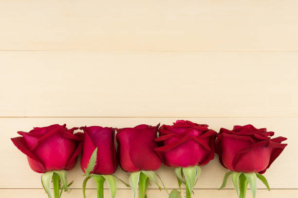 istock Red roses on light brown wood background with copy space from top view 901075180