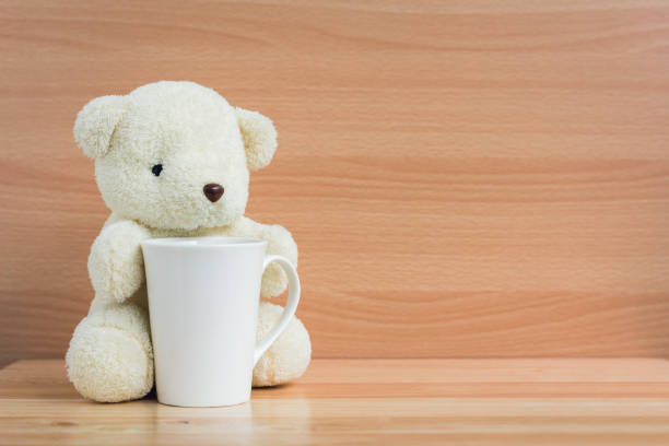 istock Bear and cup on brown wood background 901081942