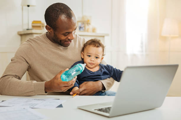 istock Gleeful father feeding his son 901085916