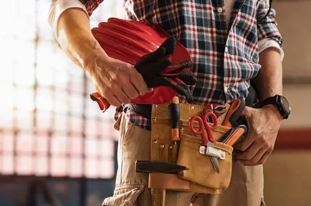 Photo of Bricklayer holding construction tools