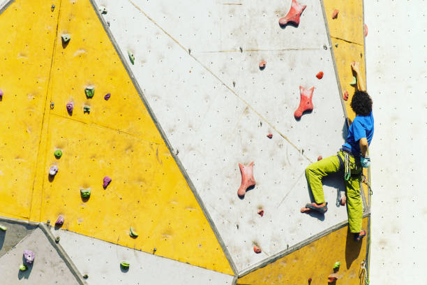 istock Man climber on artificial climbing wall in bouldering gym 901090144