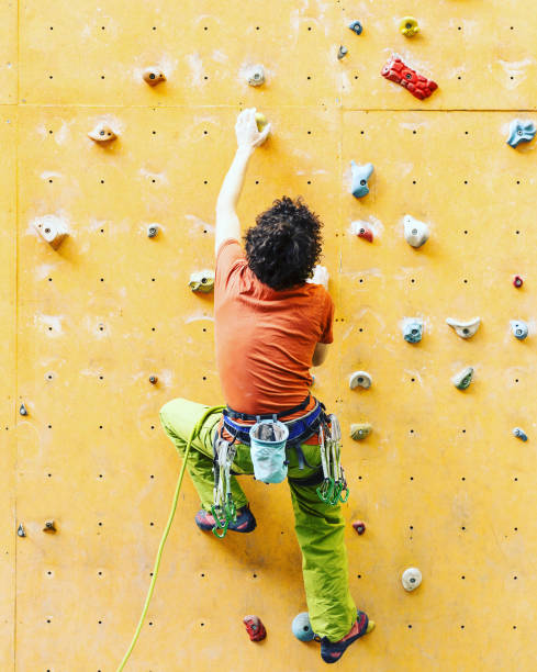 istock Man climber on artificial climbing wall in bouldering gym 901090166