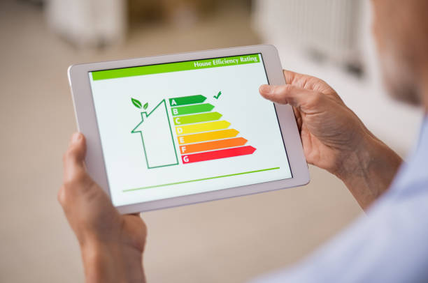 Energy efficiency house Hand holding digital tablet and looking at house efficiency rating. Detail of house efficiency rating on digital tablet screen. Concept of ecological and bio energetic house. Energy class. energy efficient stock pictures, royalty-free photos & images