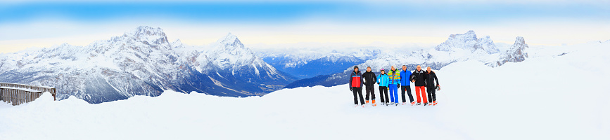 Group of skiers posing at ski resort Dolomites in Italy.  High mountain snowy landscape. Cortina d'Ampezzo mountain range, Italian Alps.