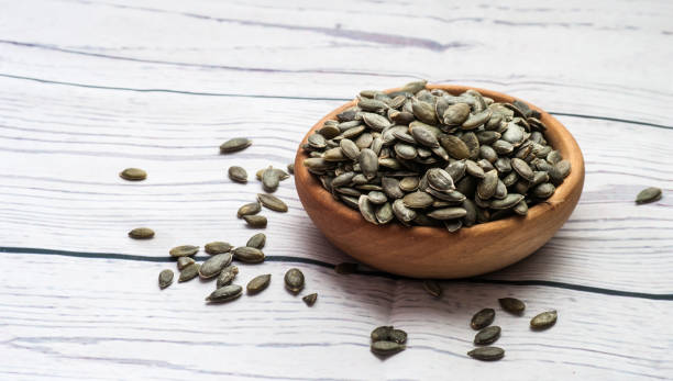 istock Raw pumpkin seeds, food background, top view 901097234