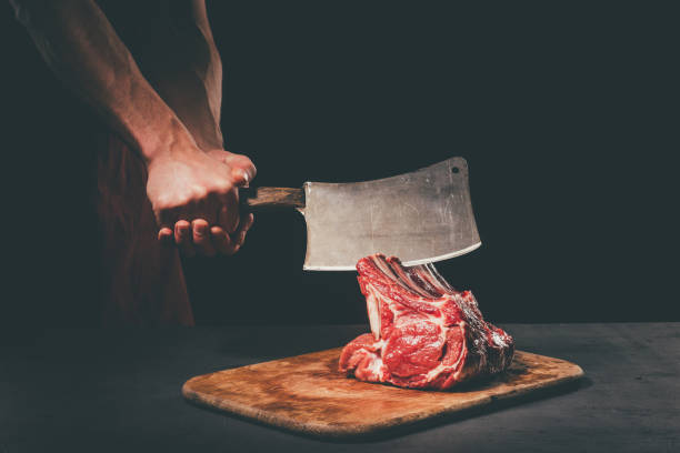 istock butcher cutting raw meat with cleaver 901101718