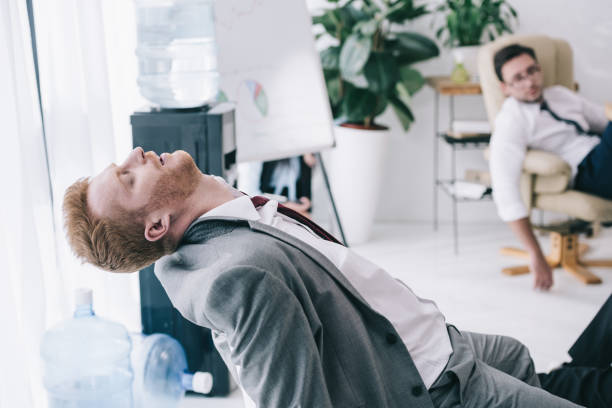 istock exhausted businessman sleeping on chair at messy office 901108646