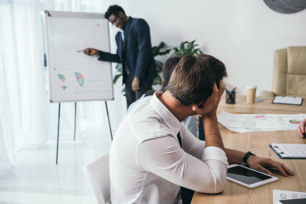 istock exhausted businesspeople listening presentation at office 901109134