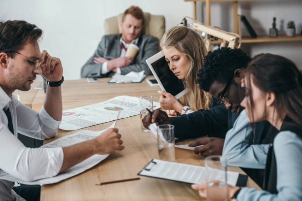 istock exhausted zombie like businesspeople having conversation at office 901109948