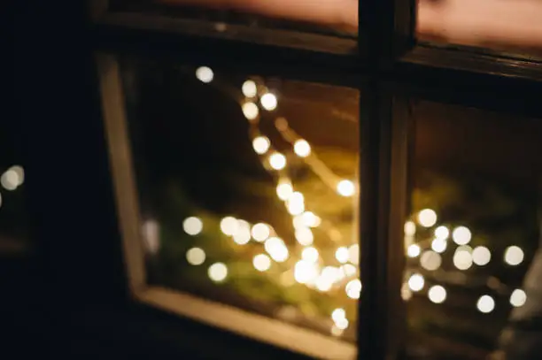 Light decorations during Christmas holiday season on windows - defocused view of lights with bokeh