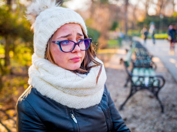 istock Sad girl sitting on a bench at public park contemplating thinking about her problems 901118432