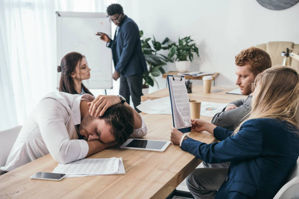 istock sleepy businesspeople having conversation at office 901121374