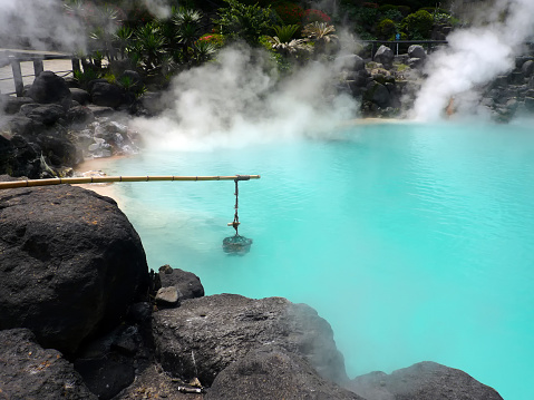 famous hot spring in Beppu Oita, Japan. There are eggs in basket in blue color water and steaming.