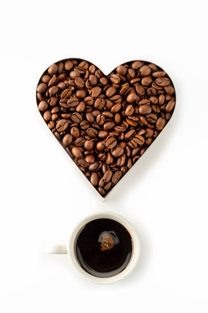 Coffee beans in a Heart Shape Cookie Cutter Isolated on a white background and one cup of coffee