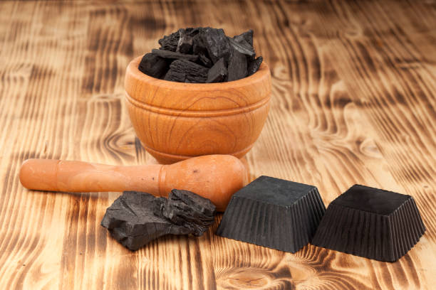 istock two hand made black soap from activated carbon on a wooden plank 901130300
