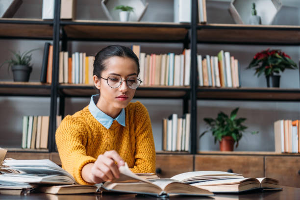 istock girl preparing for exam at library and reading book 901133590