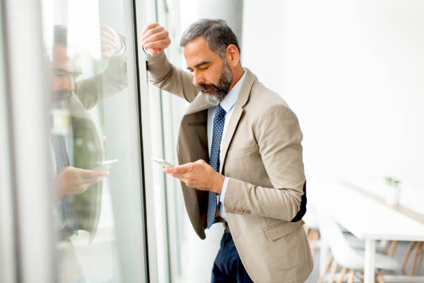 istock Handsome mature businessman  with mobile phone 901135054