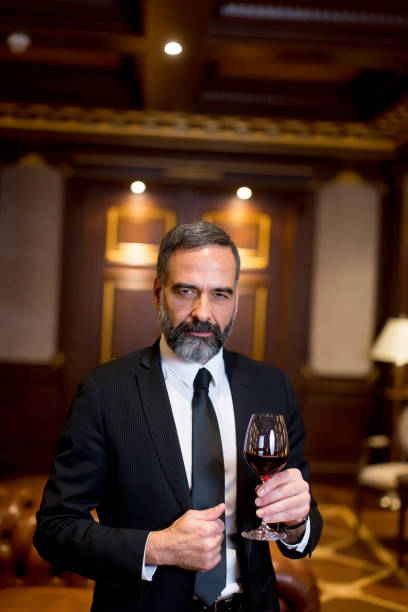 istock Handsome elegant businessman drinking red wine in bar 901138210