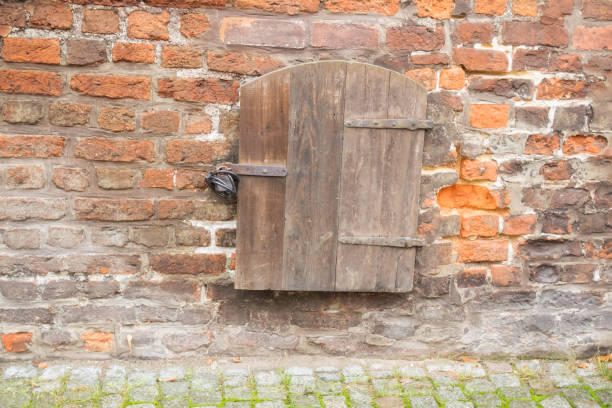 istock Small wooden door with lock in stone wall 901141332