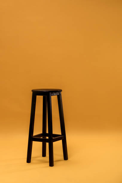 istock Dark wooden bar stool on orange background 901142110