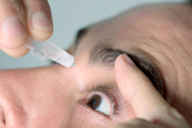 istock man applying eye drops to his eyes 901145564