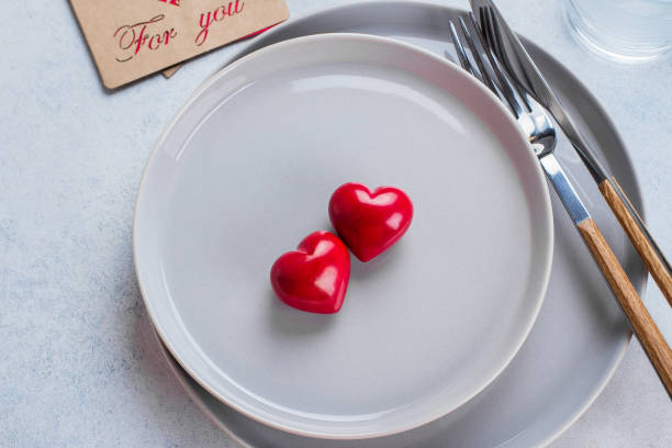 istock Valentine's day background table setting with two ceramic hearts on plate. Top view, copy space 901149584