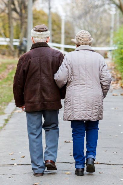 istock Elderly couple walking in the park 901149782