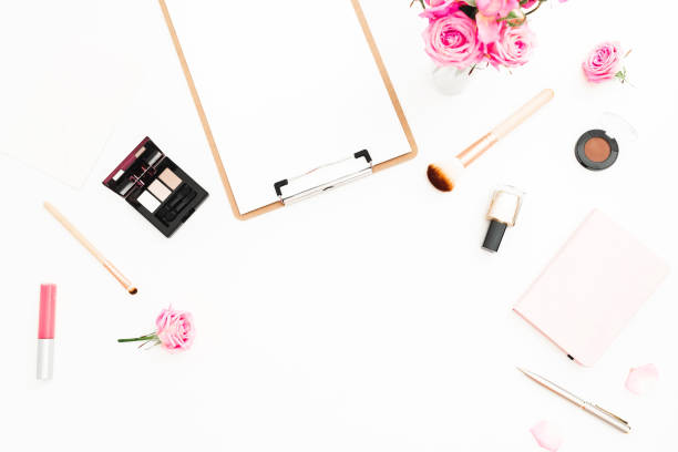 istock Feminine workspace with pink roses bouquet, cosmetics, diary and clipboard on white background. Top view. Flat lay. Beauty blog, copy space 901173566