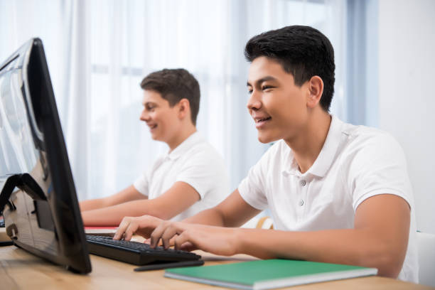 istock young happy teenager boys studying on computers 901178190